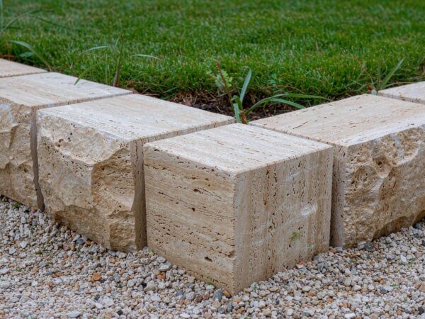A line of travertine garden edging separating gravel from lawn