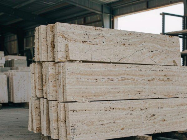 A stack of thick travertine stair treads with eased arris edges on a pallet