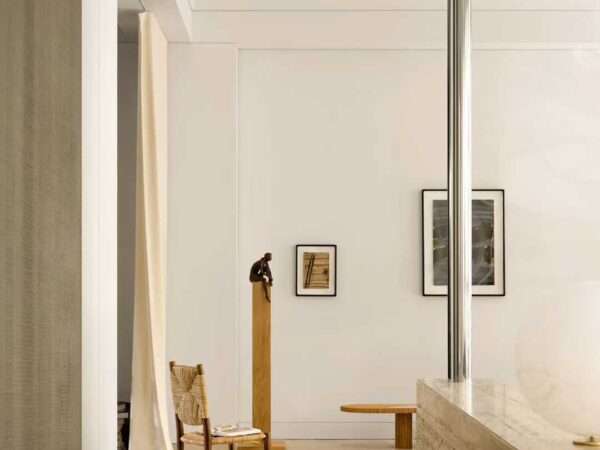 A long travertine counter with glass display cases beside it in a gallery interior