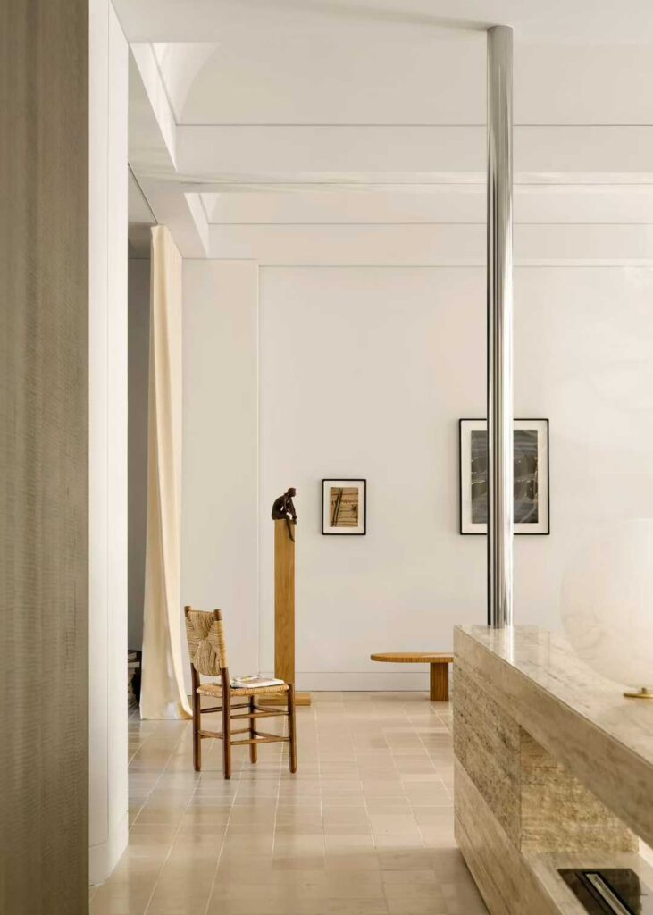 A long travertine counter with glass display cases beside it in a gallery interior