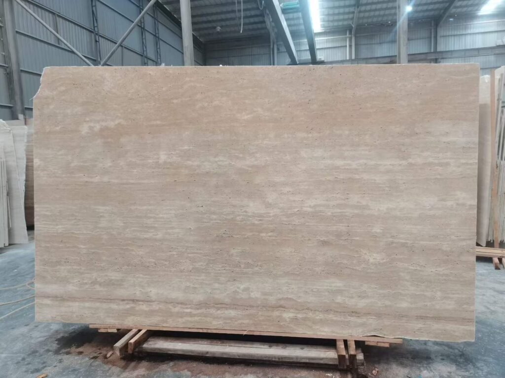 Travertine cladding on a corner column beside a window and a curtain in a pale interior