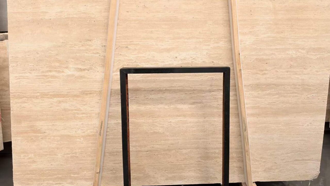 Rows of travertine slabs stored upright on timber racks, the cut faces toward the viewer