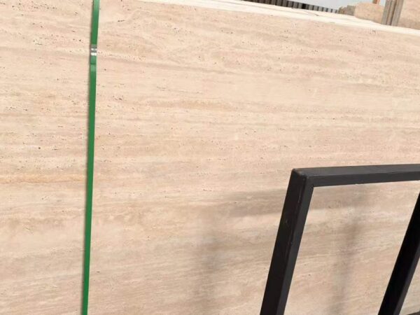 A single travertine slab standing on a steel frame, showing clear horizontal bedding across its face