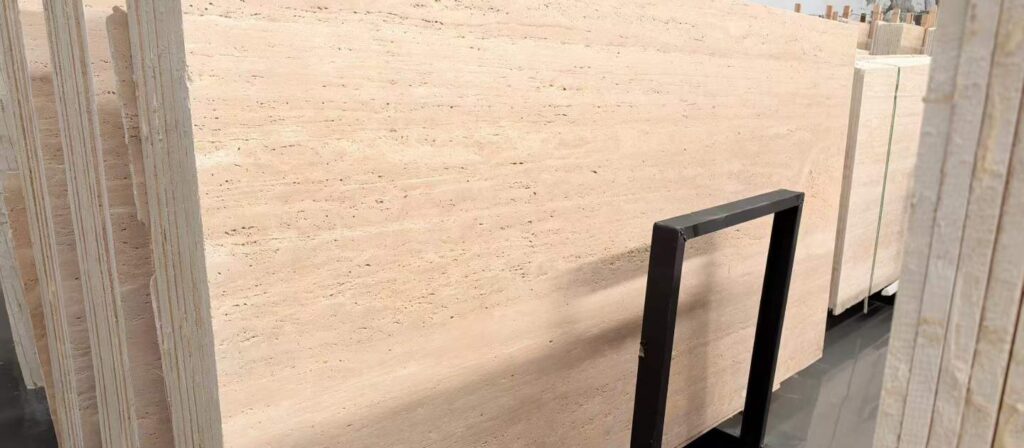 A tall travertine slab leaning in a storage rack, its cut face showing fine horizontal layering
